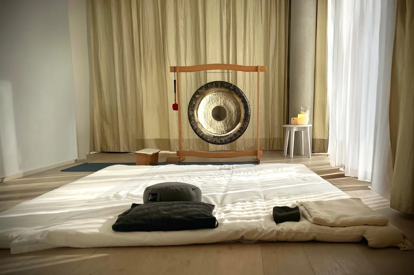 Heller Trainingsraum mit Gong, Matte und Kissen für eine Einzel-Session