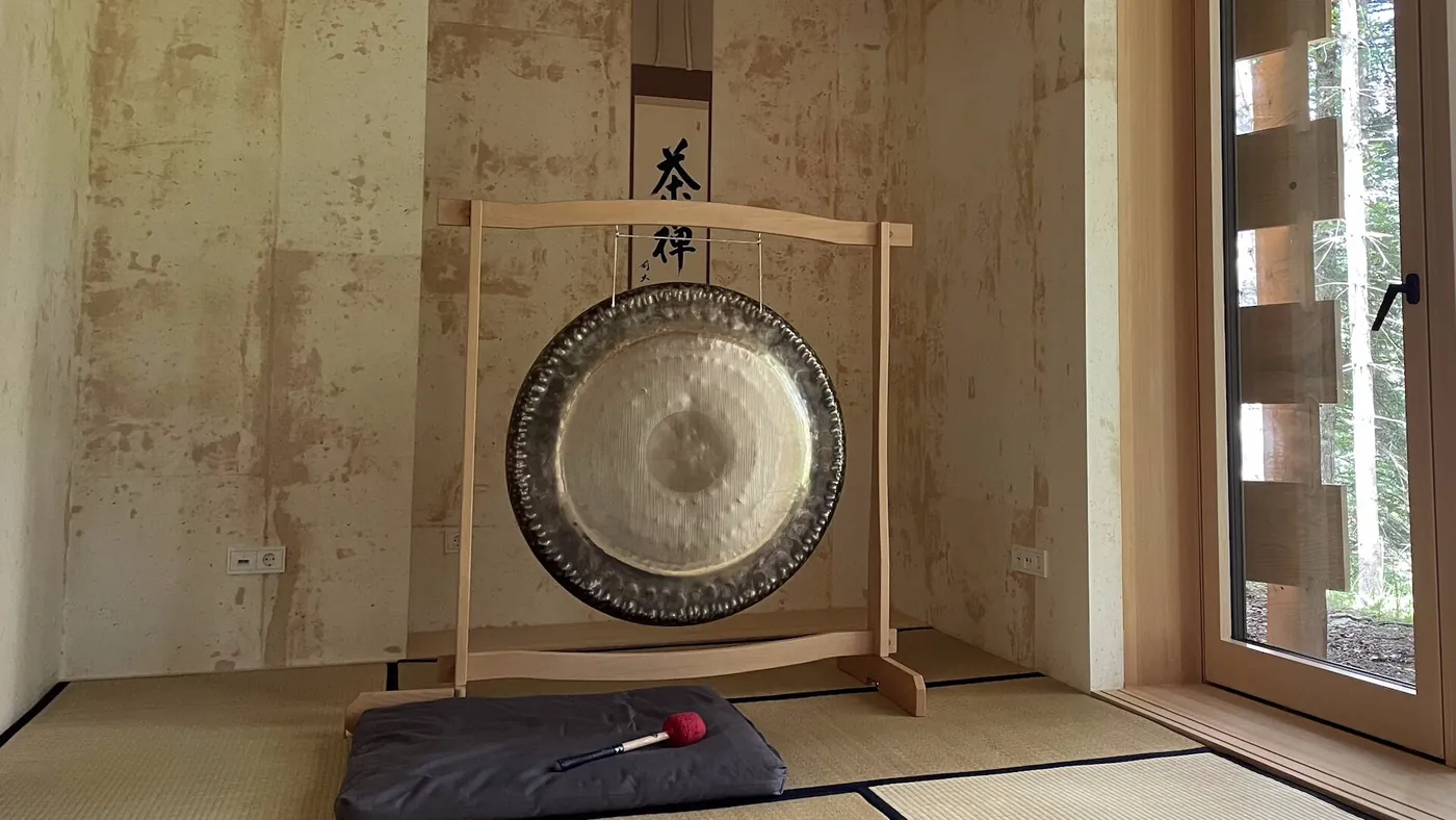 Gong auf einem Holzständer neben einer Matte in einem ruhigen Raum