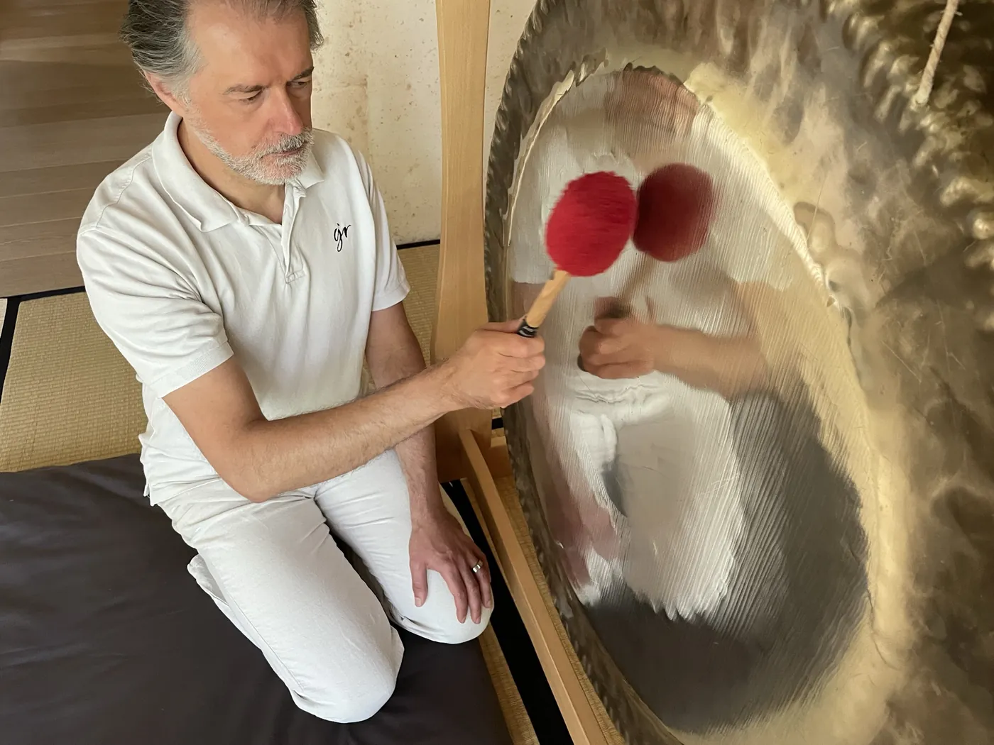 Alexander Renner spielt den Gong mit zwei roten Schlägeln aus der Nähe