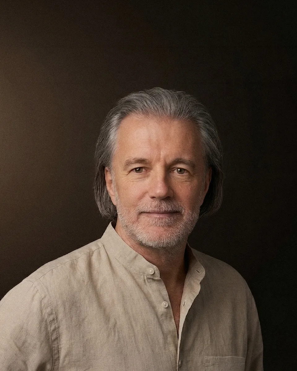 Alexander Renner im Leinenhemd vor dunklem Studiohintergrund