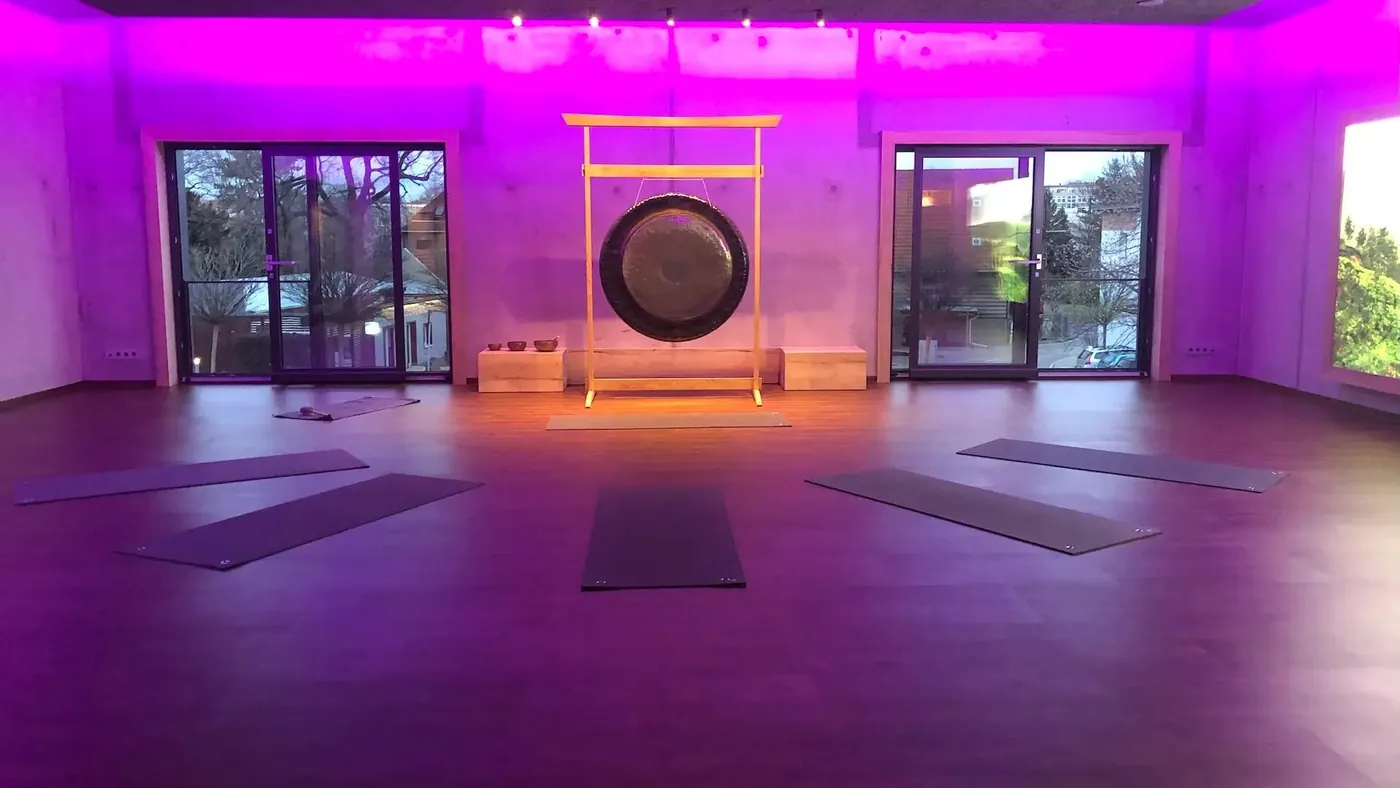 Trainingsraum in farbigem Licht, Matten ausgelegt, der Gong steht bereit